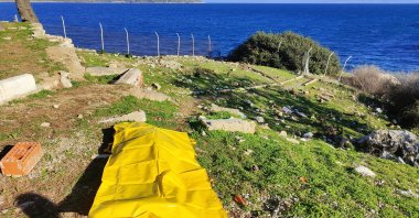 The body of one of two migrant women who drowned in the Aegean Sea after being pushed back by the Greek coast guard is taken to shore by Turkish authorities on Dec. 21, 2022. (IHA Photo)