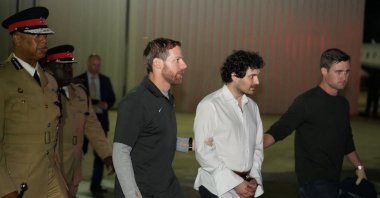 Sam Bankman-Fried, founder and former CEO of crypto currency exchange FTX, is walked in handcuffs to a plane during his extradition to the United States at Lynden Pindling international airport in Nassau, Bahamas, Dec. 21, 2022. (Reuters Photo)