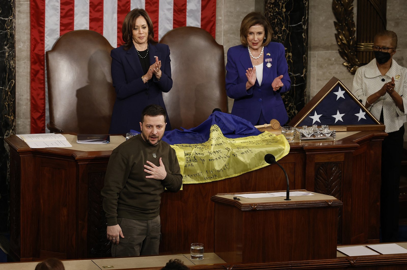 Ukraine President Volodymyr Zelenskyy (L) thanks members of Congress after presenting a flag signed by Ukrainian troops to U.S. House Speaker Nancy Pelosi (2nd R) and Vice President Kamala Harris (C) during a joint meeting of Congress, Washington, D.C., U.S., Dec. 21, 2022. (AFP Photo)