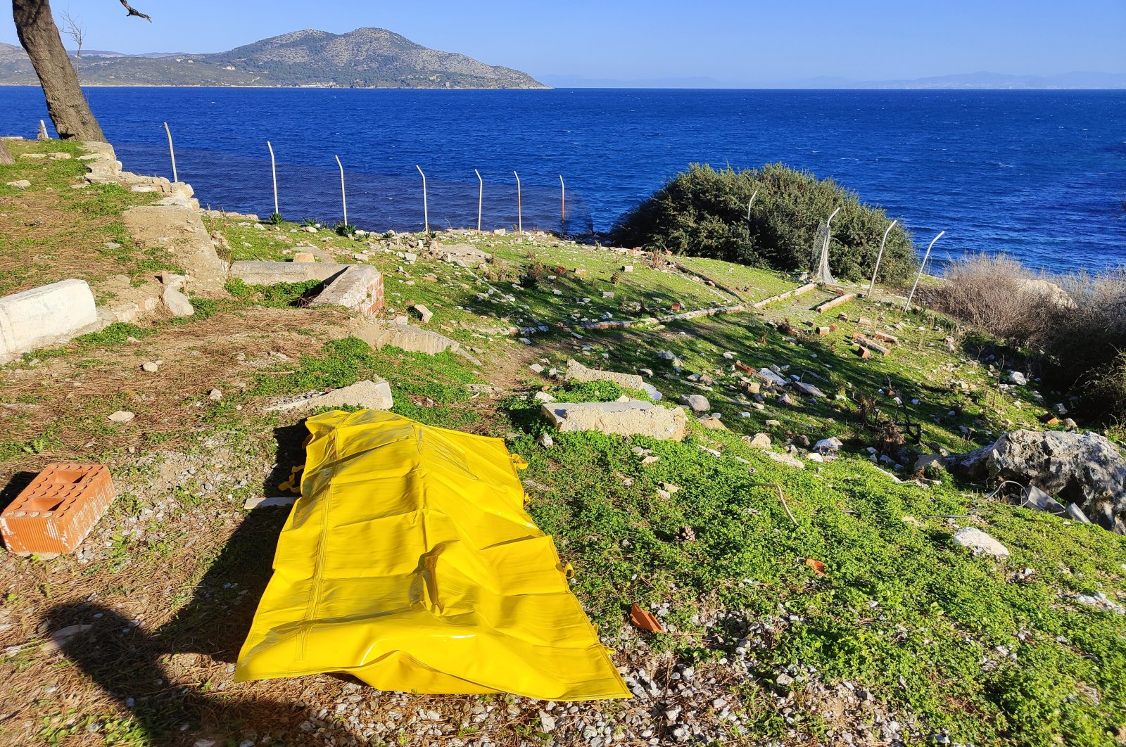 The body of one of two migrant women who drowned in the Aegean Sea after being pushed back by the Greek coast guard is taken to shore by Turkish authorities on Dec. 21, 2022. (IHA Photo)