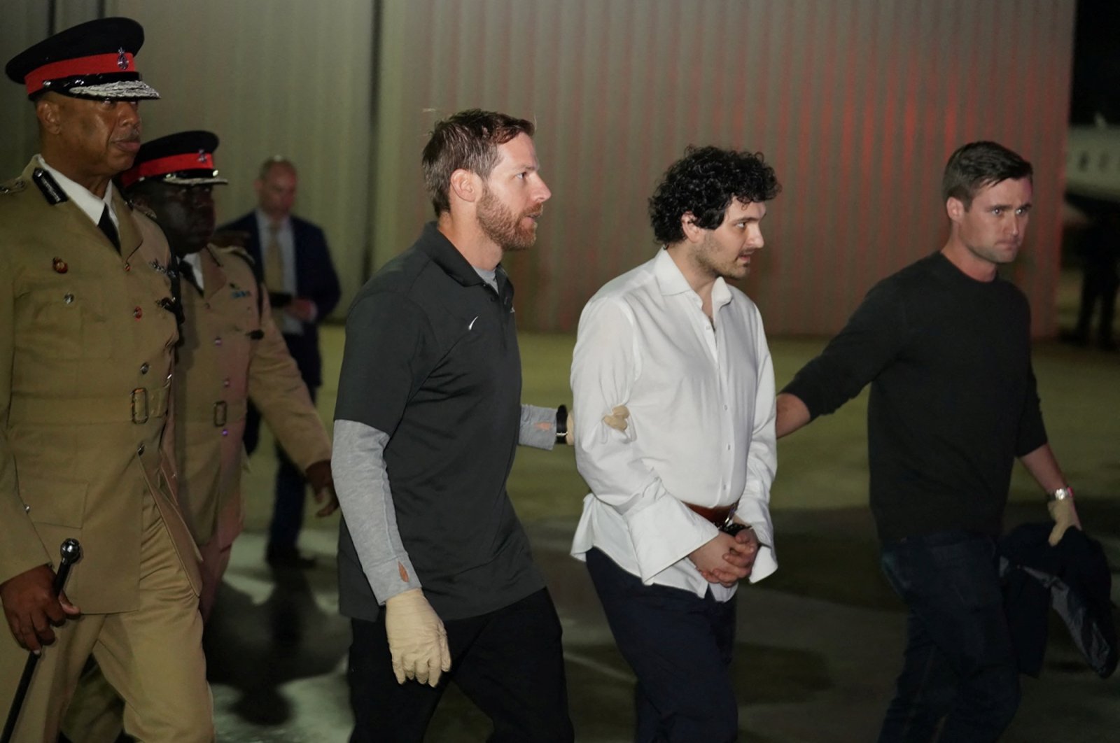 Sam Bankman-Fried, founder and former CEO of crypto currency exchange FTX, is walked in handcuffs to a plane during his extradition to the United States at Lynden Pindling international airport in Nassau, Bahamas, Dec. 21, 2022. (Reuters Photo)
