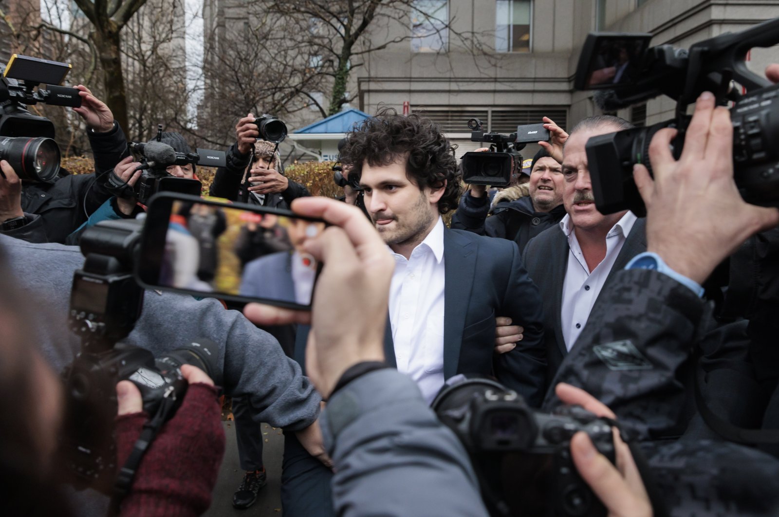 Cryptocurrency entrepreneur Sam Bankman-Fried (C) is led out of a U.S. federal courthouse after being released on bail following an arraignment, New York, U.S., Dec. 22. 2022. (EPA Photo)