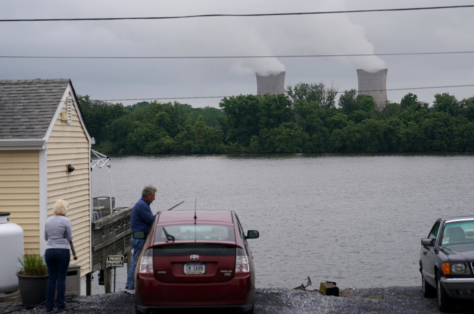 People work on a car across the Susquehanna River in front of the Three Mile Island Nuclear Power Plant in Goldsboro, Pennsylvania, U.S. May 30, 2017. (Reuters Photo)