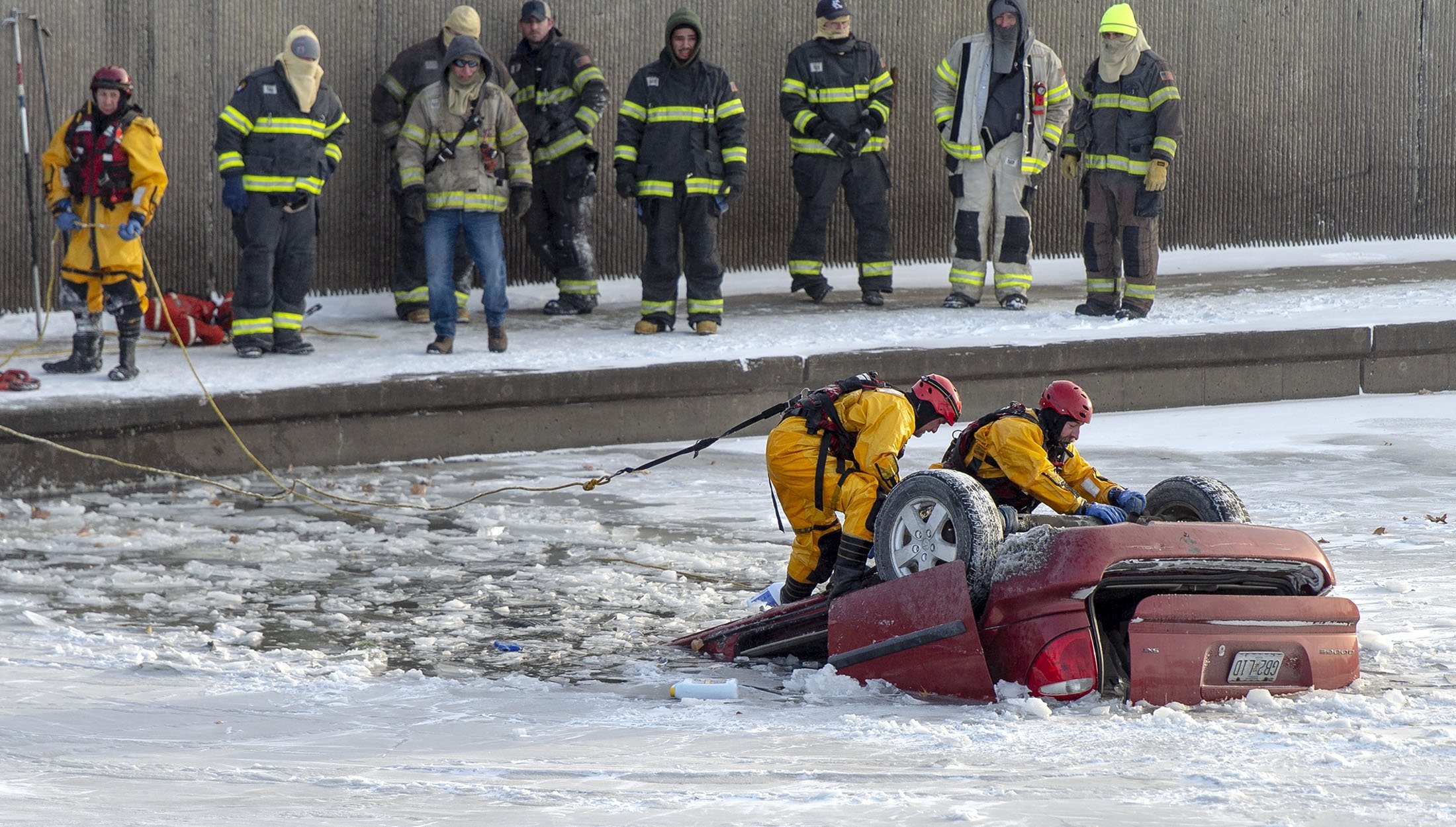 Petugas penyelamat pemadam kebakaran Kansas City bekerja untuk memulihkan minivan yang masuk ke Brush Creek di Kansas City, Missouri, AS, 22 Desember 2022. (Foto AP)