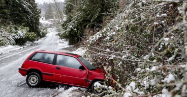 A car is left on the side of the road due to dangerous road conditions, in Seattle, U.S., Dec. 23, 2022. (AP Photo)