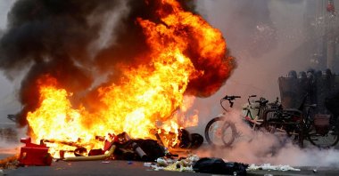 Smoke billows from a fire, as PKK terror group supporters face riot police in violent clashes, in Paris, France, Dec. 24, 2022. (Reuters Photo)