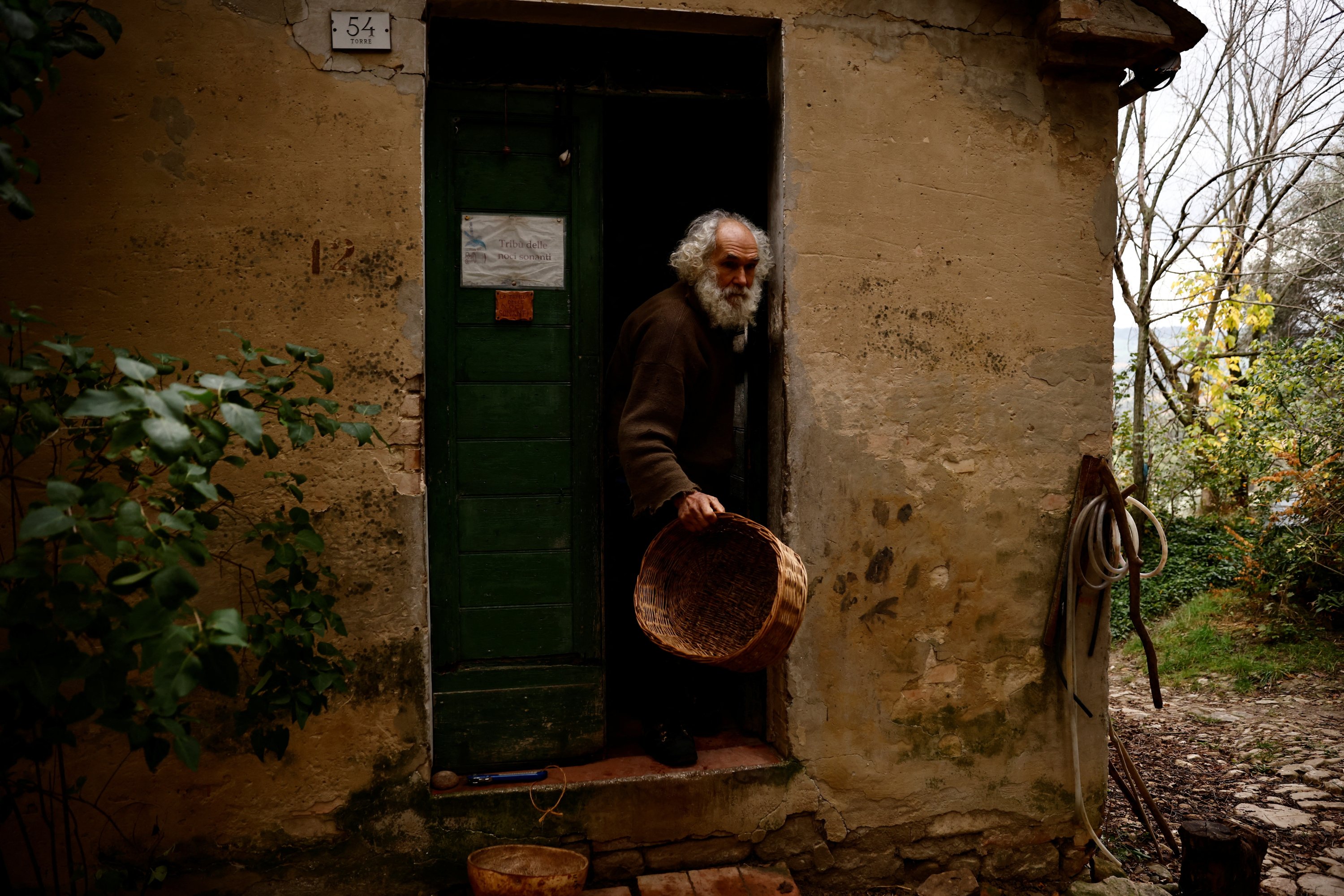 Fabrizio Cardinali, 72, membawa keranjang untuk panen zaitun, di rumahnya di hutan kota kecil Cupramontana, Ancona, Marche, Italia, 15 November 2022. (Foto Reuters)