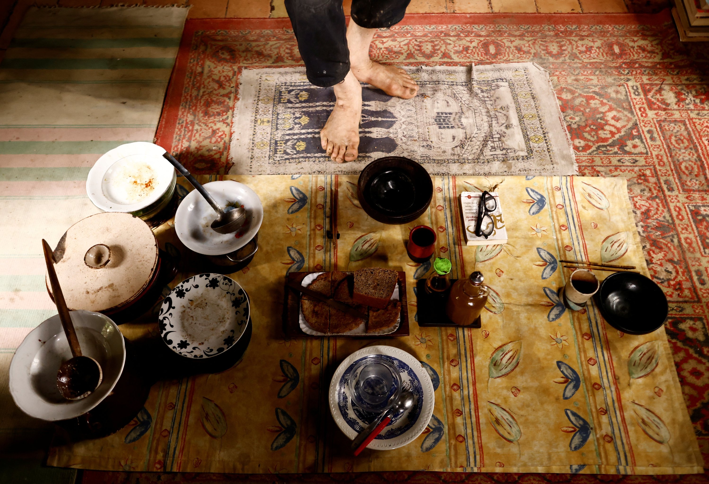 Fabrizio Cardinale, 72 anni, apparecchia la tavola per il pranzo, nella sua casa nei boschi della cittadina di Cupramontana, Ancona, Marche, Italia, 15 novembre 2022. (Foto Reuters)