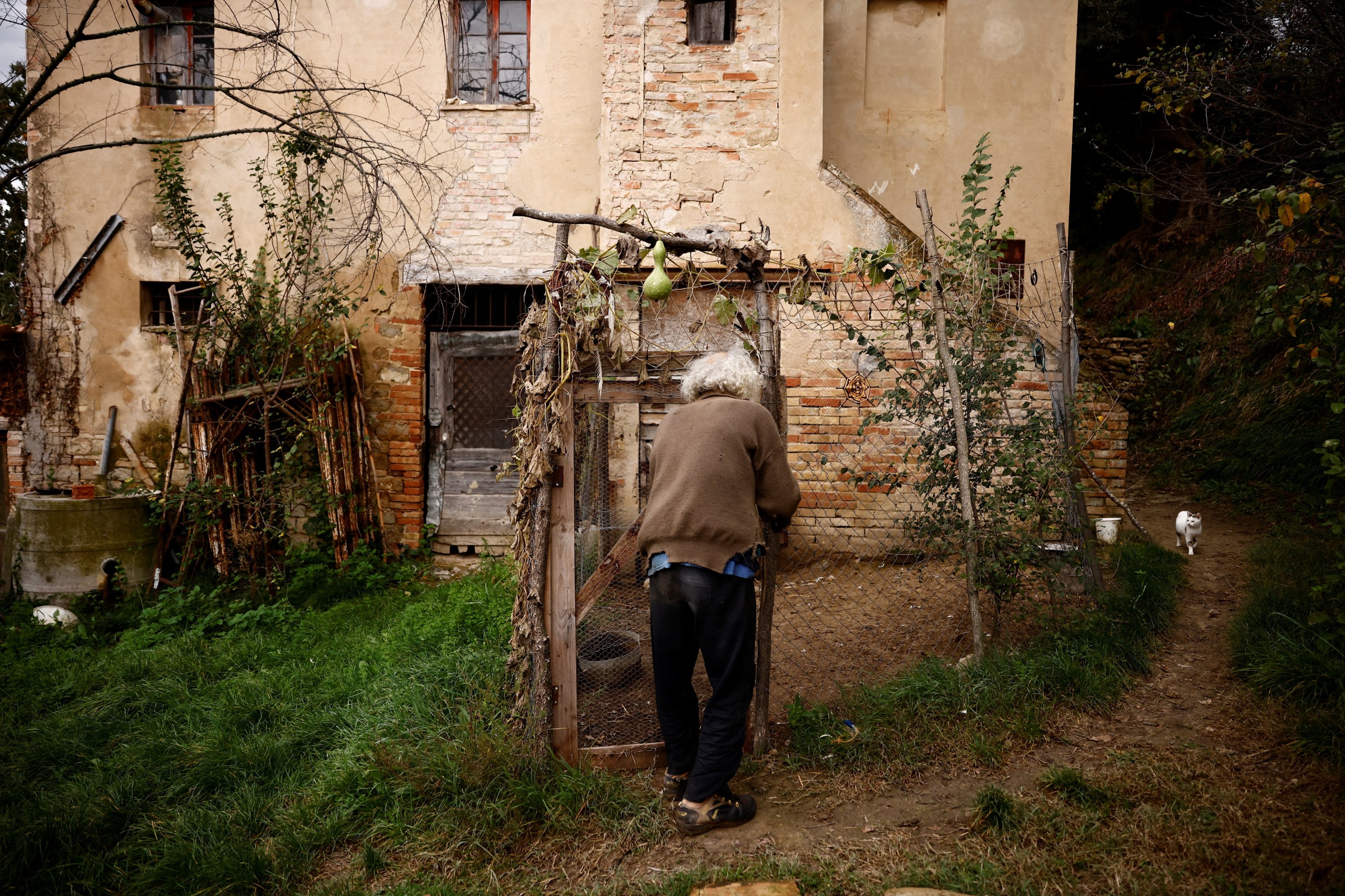 Fabrizio Cardinale, 72 anni, ispeziona il pollaio nella sua casa nei boschi della cittadina di Cupramontana, Ancona, Marche, Italia, 15 novembre 2022. (Foto Reuters)