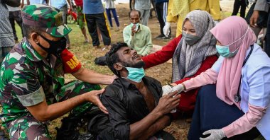Health workers check a Rohingya refugee who was feeling sick after his arrival by boat in Krueng Raya, Indonesia, Dec. 25, 2022. (AFP Photo)
