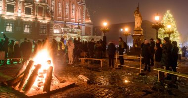 People stand around a fire during the Winter Solstice celebration at the Town Hall Square, in Riga, Latvia, Dec. 21, 2022. (AFP Photo)