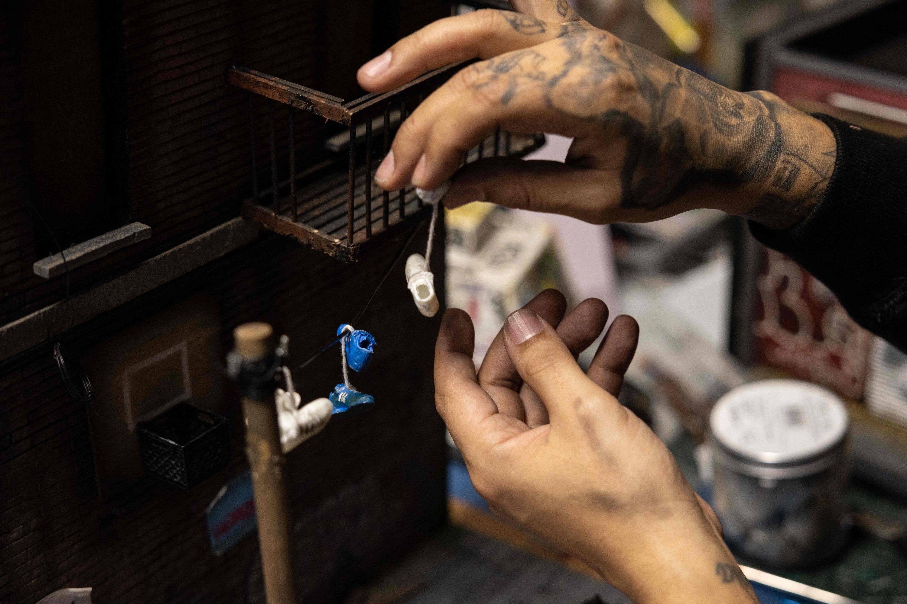 Danny Cortes, seniman miniatur jalanan, mengerjakan miniatur baru di studionya di wilayah Brooklyn di New York City, AS, 19 Desember 2022. (Foto AFP)