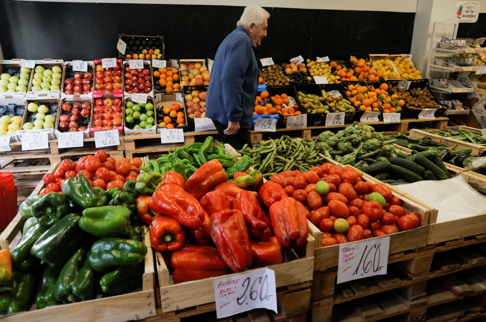 A customer walks between fruits and vegetables displayed in boxes at a fruit store as the Spanish government announces measures to battle inflation, in Ronda, Spain, Dec. 27, 2022. (Reuters Photo)