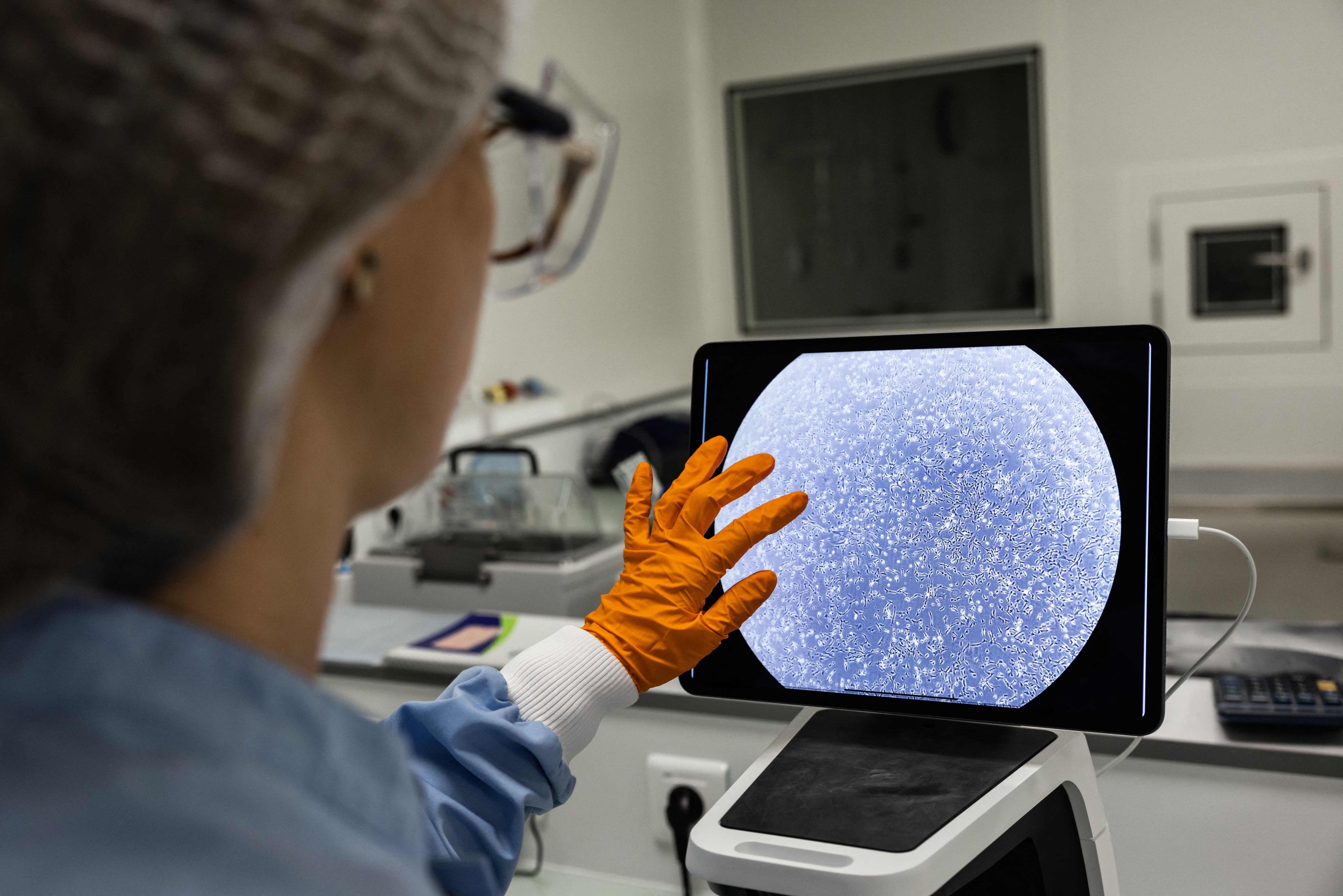 Seorang operator menghitung sel di bawah mikroskop di laboratorium Urgo yang didedikasikan untuk proyek Genesis di situs Urgo di Chenove, Prancis, 16 Desember 2022. (Foto AFP)