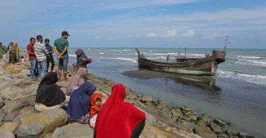 Villagers look at a wooden boat used by Rohingya people in Pidie, Aceh province, Indonesia, Dec. 27, 2022. (AFP Photo)