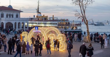People click pictures of a 2023 New Year-themed lighting at Kadıköy pier, in Istanbul, Türkiye, Dec. 24, 2022. (Shutterstock Photo)