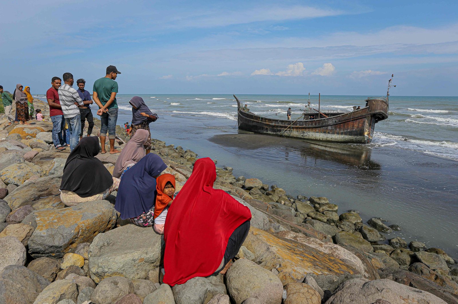 Villagers look at a wooden boat used by Rohingya people in Pidie, Aceh province, Indonesia, Dec. 27, 2022. (AFP Photo)