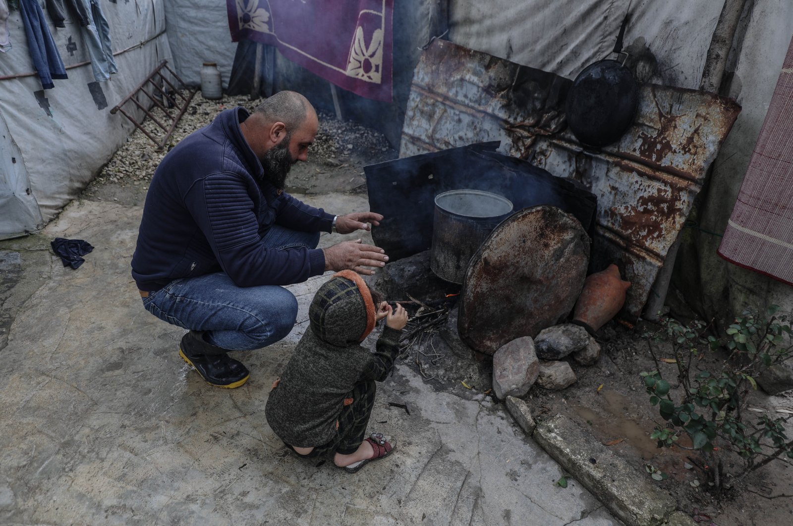 A family is seen trying to stay warm during winter in Idlib province&#039;s Ataa camp for displaced Syrians, Syria, Dec. 25, 2022 (AA Photo)