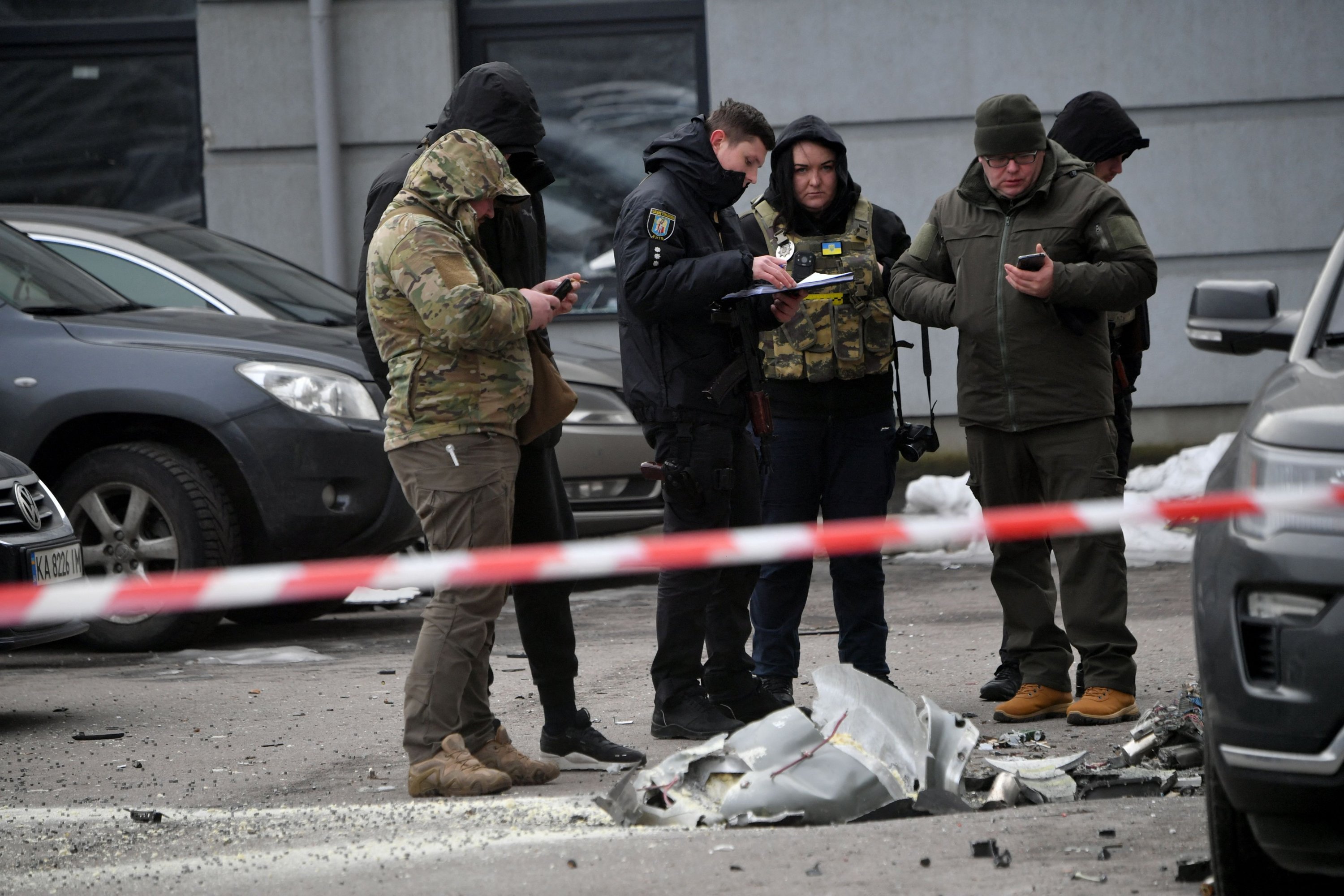 Pakar polisi memeriksa sisa-sisa peluru kendali yang jatuh di kendaraan yang diparkir di gedung perumahan bertingkat, Kyiv, Ukraina, 29 Desember 2022. (Foto AFP)