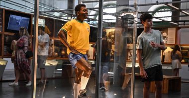 A visitor poses for a picture next to a wax figure of Brazil's football legend Pele at the Pele Museum, in Santos, Brazil, Dec. 27, 2022. (AFP Photo)