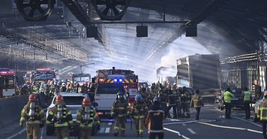 Firefighters work to extinguish a fire on a highway in Gwacheon, South Korea, Dec. 29, 2022. (AP Photo)