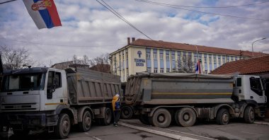 A pedestrian walks past a road barricade set up in the divided town of Mitrovica, Kosovo, Dec. 28, 2022. (AFP Photo)