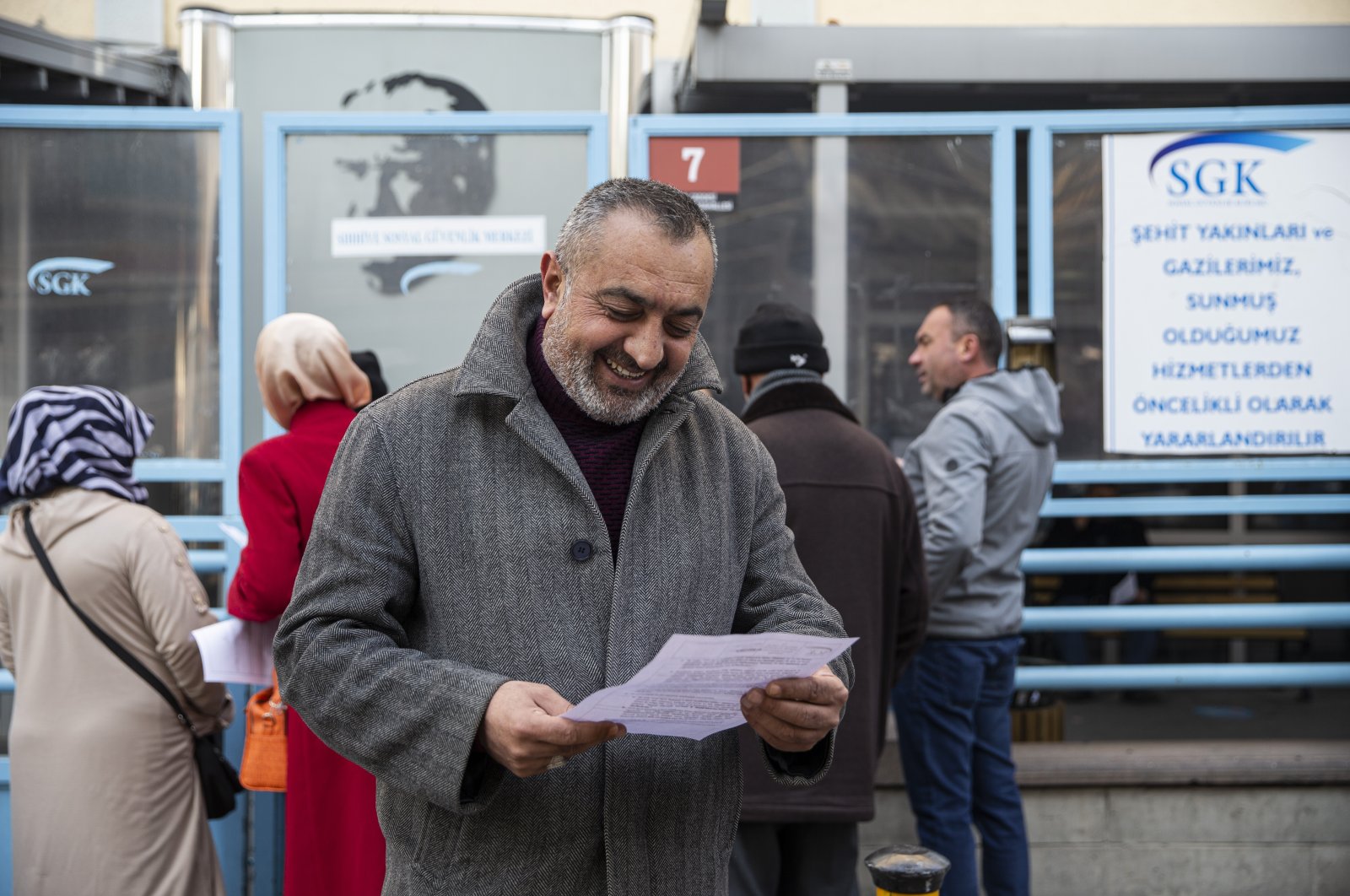 A citizen smiles while looking at papers allowing him to retire in line with the new regulation, Ankara, Türkiye, Dec. 29, 2022. (AA Photo)