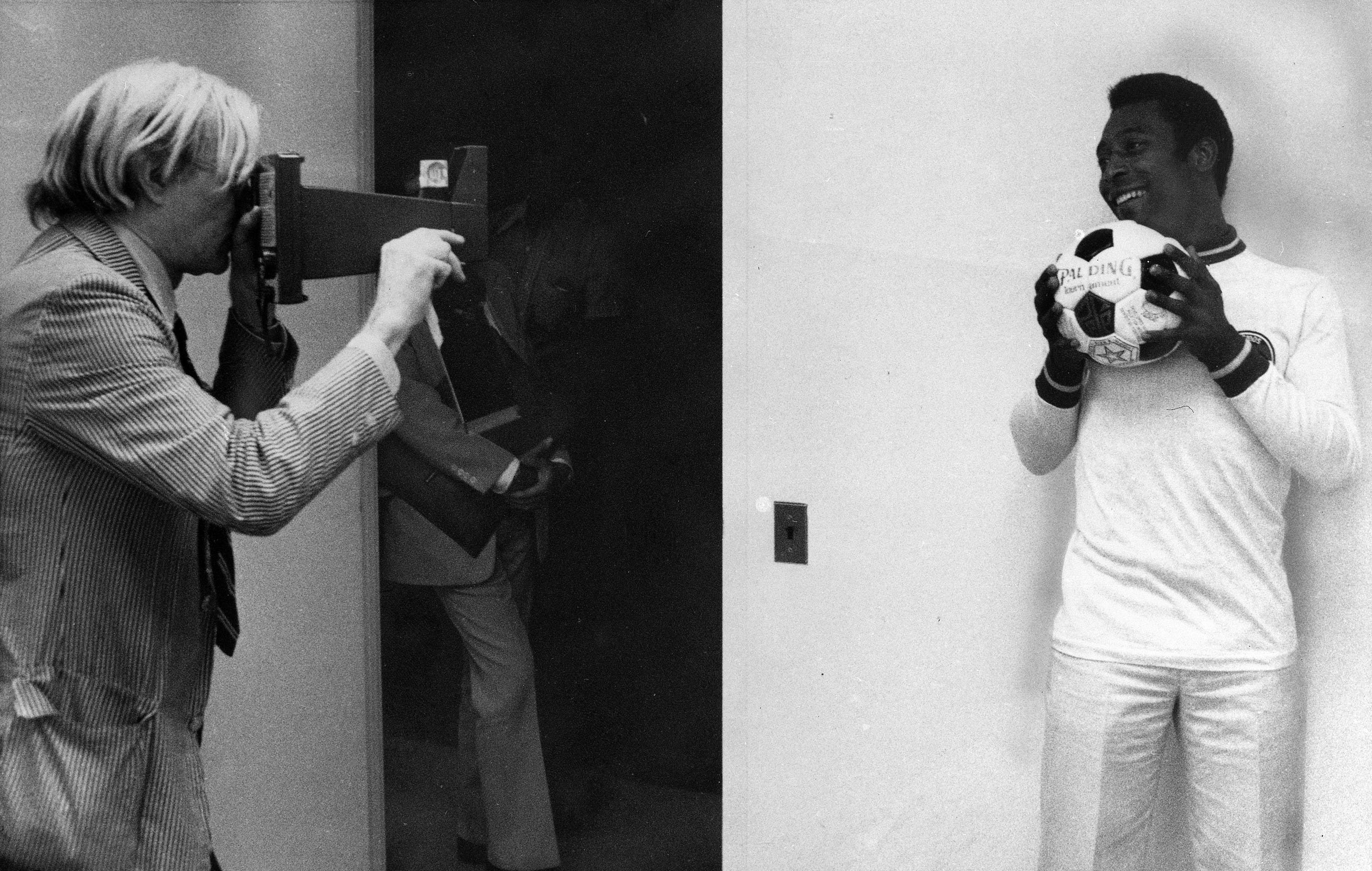 Artis surealis Andy Warhol berbicara dengan pemain sepak bola Brasil Pele tentang potret setelah Warhol ditugaskan untuk membuat serangkaian potret bintang atletik di New York, AS, 26 Juli 1997. (Foto AP)