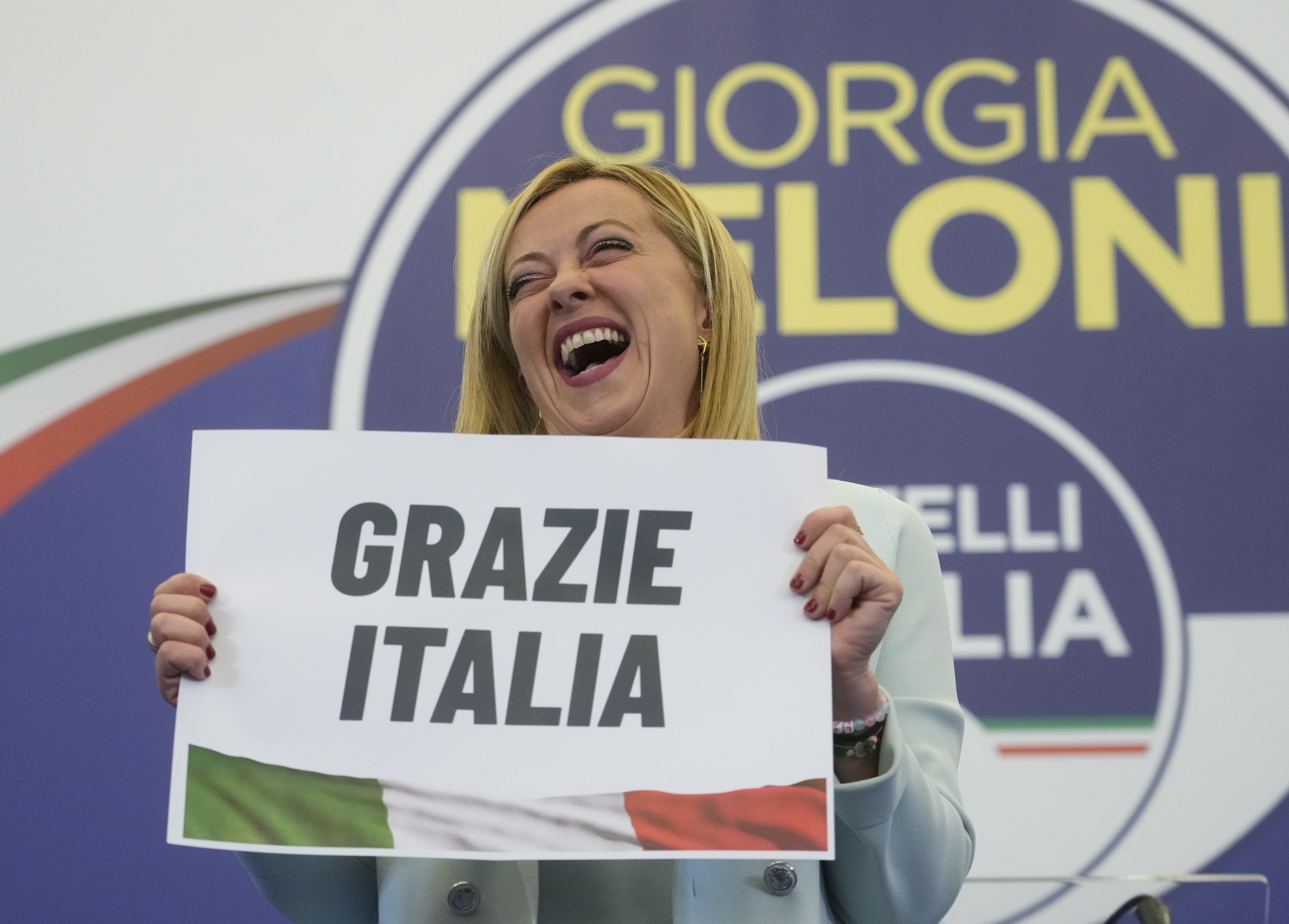 Giorgia Meloni dari Italia menunjukkan plakat bertuliskan 'Terima kasih, Italia' dalam bahasa Italia di markas pemilihan partainya di Roma, Italia, 26 September 2022. (Foto AP)