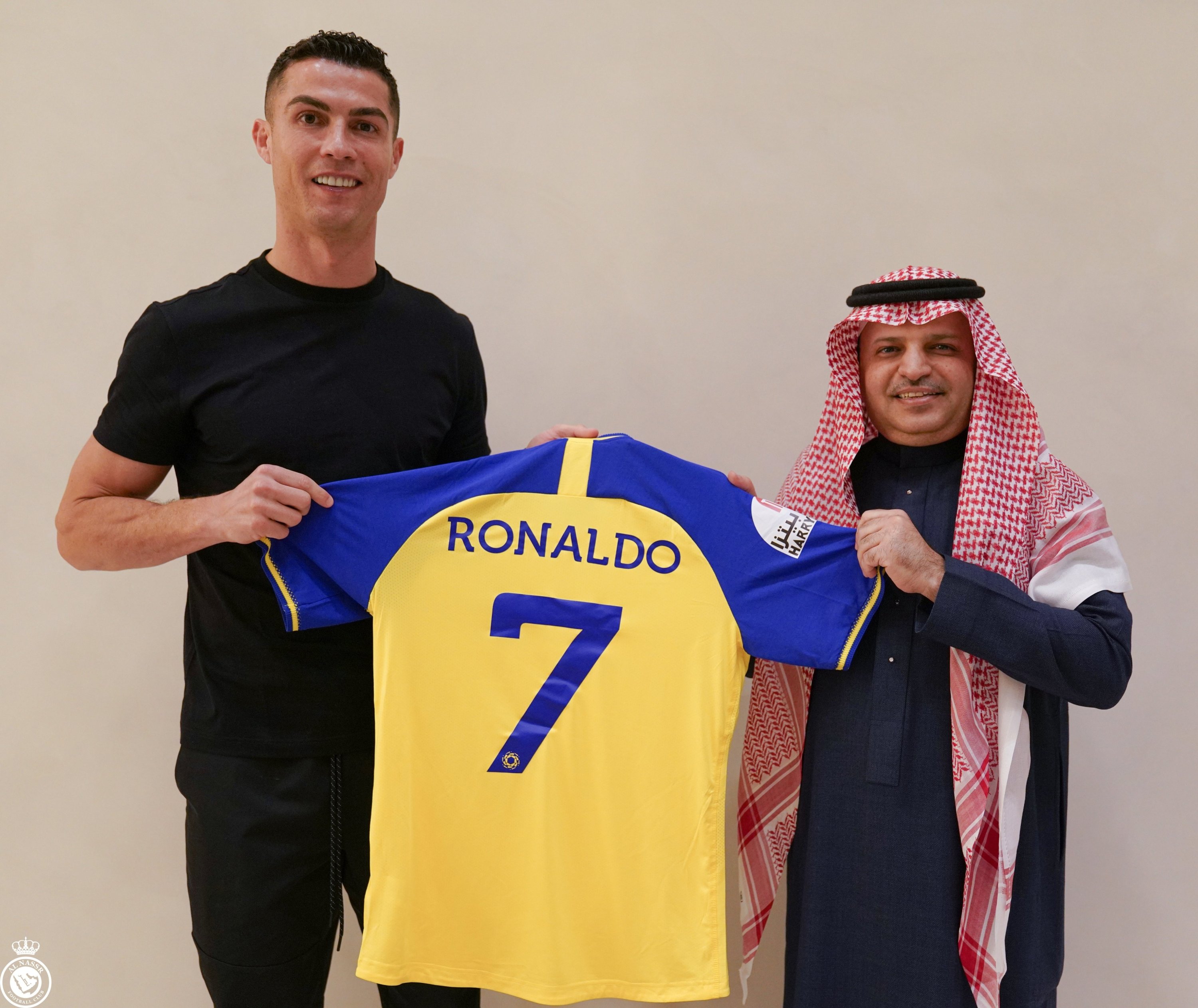 Cristiano Ronaldo mengangkat jersey Al Nassr barunya.