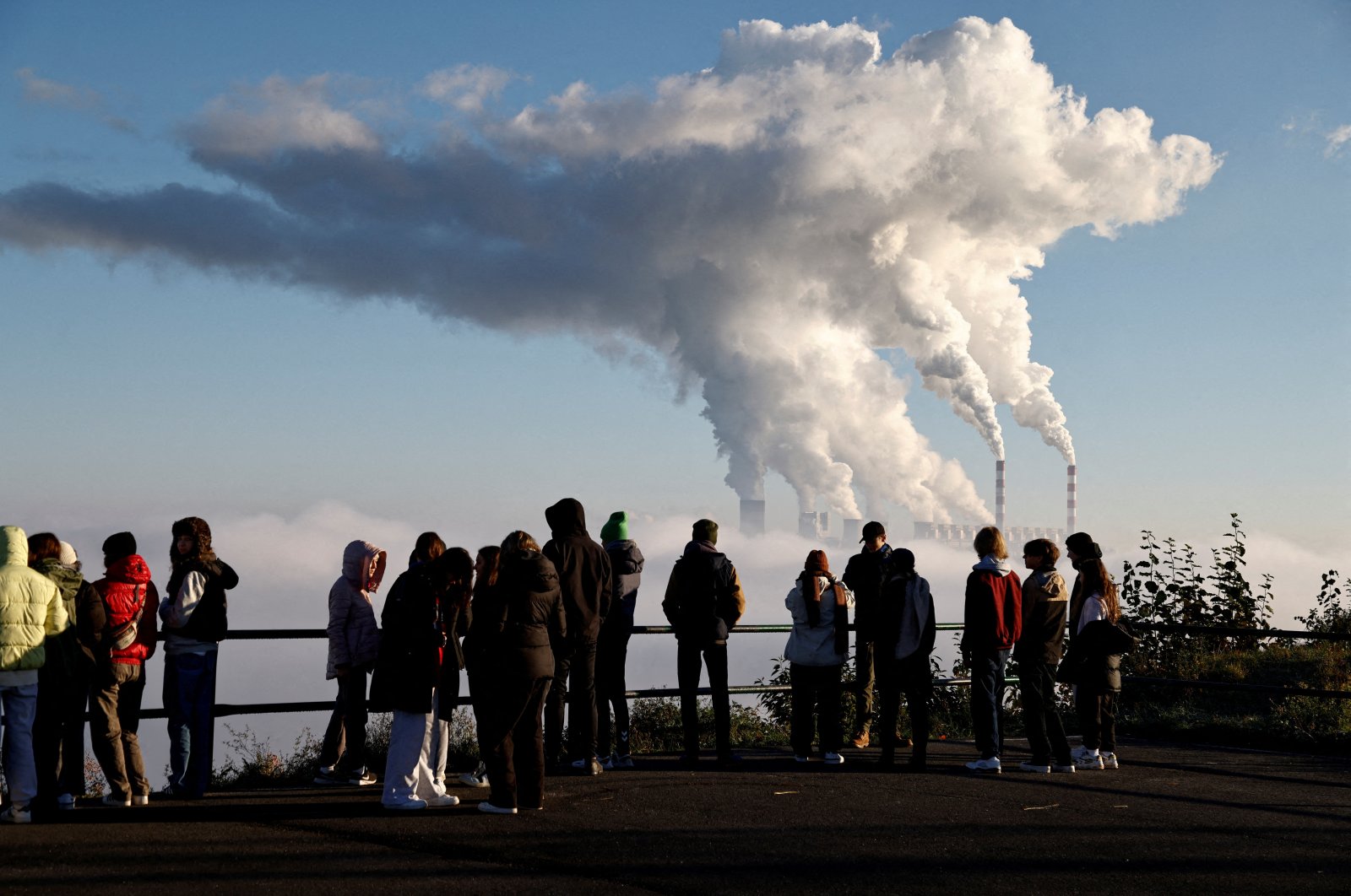 People watch smoke and steam billow from Belchatow Power Station, Europe&#039;s largest coal-fired power plant powered by lignite, in Zlobnica, Poland, Oct. 20, 2022. (Reuters Photo)