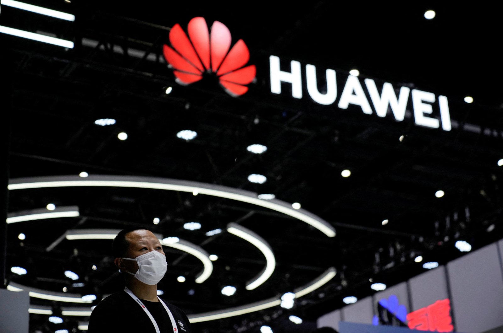 A person stands by a sign of Huawei during World Artificial Intelligence Conference, following the COVID-19 outbreak, in Shanghai, China, Sept. 1, 2022. (Reuters Photo)