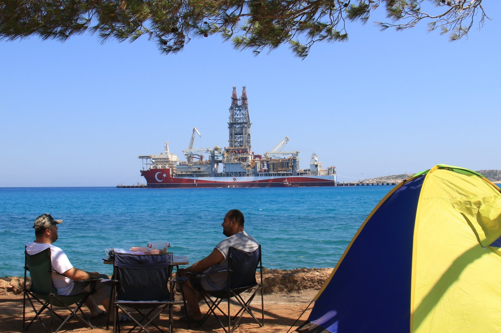 Two men camp near a port where Abdülhamid Han drillship stands docked, in Mersin, southern Türkiye, June, 20, 2022. (IHA Photo)