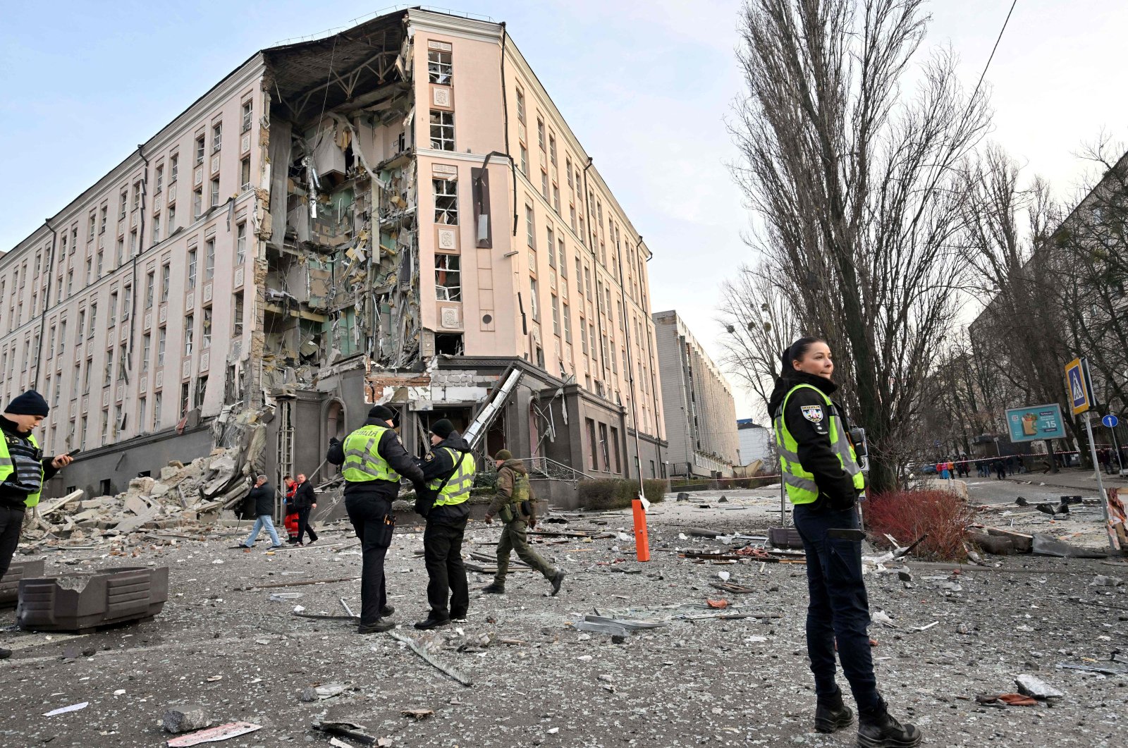 Rescuers and policemen work at the bottom of a hotel, which has been partially destroyed by a Russian strike in the center of the Ukrainian capital, Kyiv on Dec. 31, 2022. (AFP Photo)