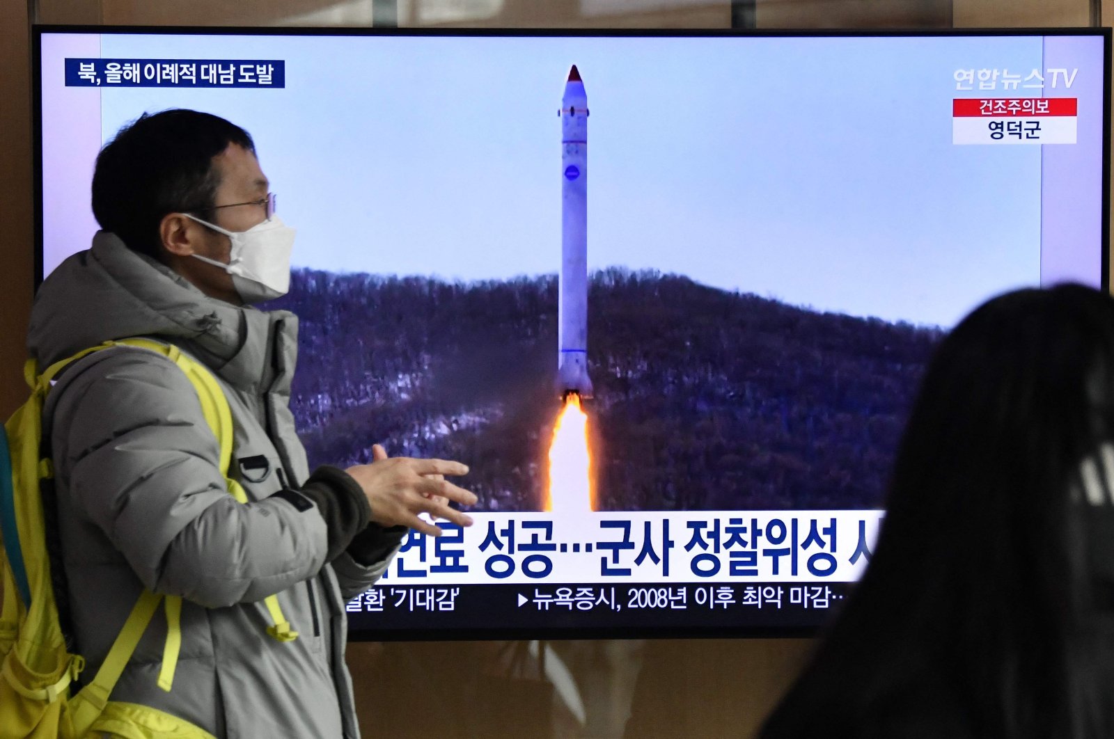 A man walks past a television screen showing a news broadcast with file footage of a North Korean missile test, at a railway station in Seoul on Dec. 31, 2022. (AFP Photo)