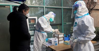 A medical worker in protective suit registers information for a patient at the entrance to the fever clinic of the Central Hospital of Wuhan, in Wuhan, Hubei province, China, Dec. 31, 2022. (Reuters Photo)