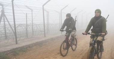 Border Security Force (BSF) personnel patrol along the border fence on bicycles during a cold foggy morning at the India-Pakistan Wagah border near Amritsar, India, Dec. 21, 2022. (AFP Photo)
