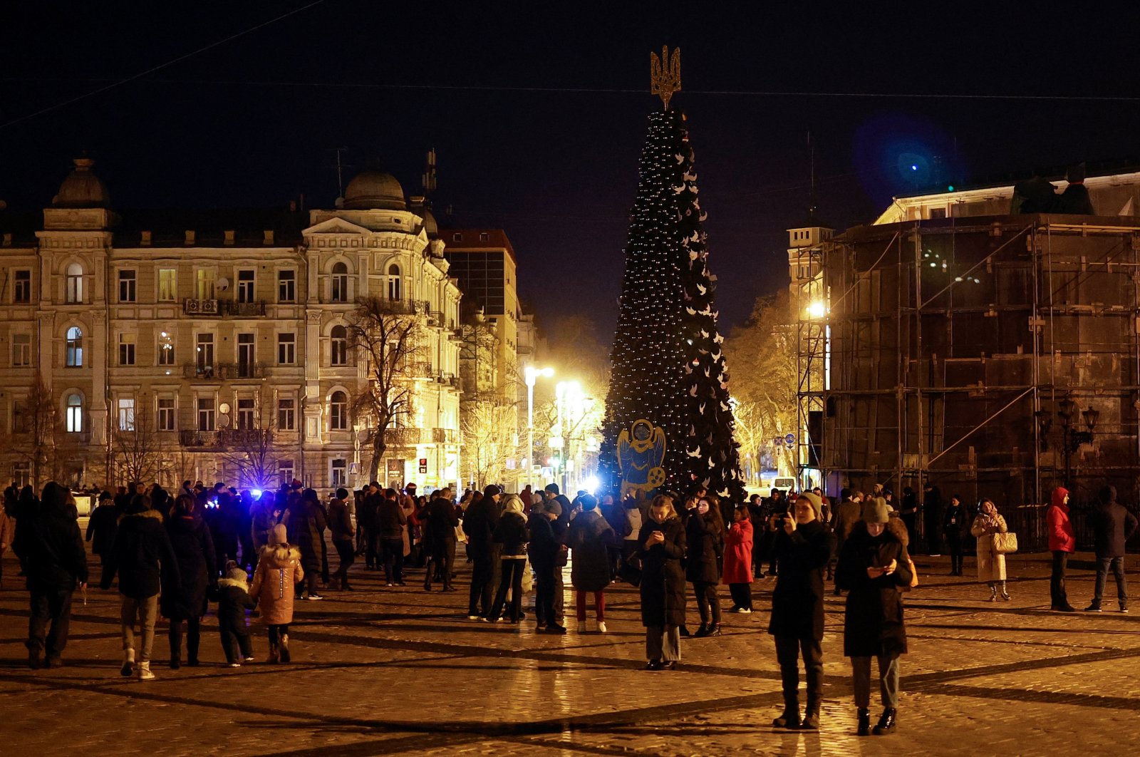 People gather next to a Christmas tree to celebrate the New Year eve before a curfew, amid Russia&#039;s attack on Ukraine, in front of the St. Sophia Cathedral in Kyiv, Ukraine, Dec. 31, 2022. (Reuters Photo)