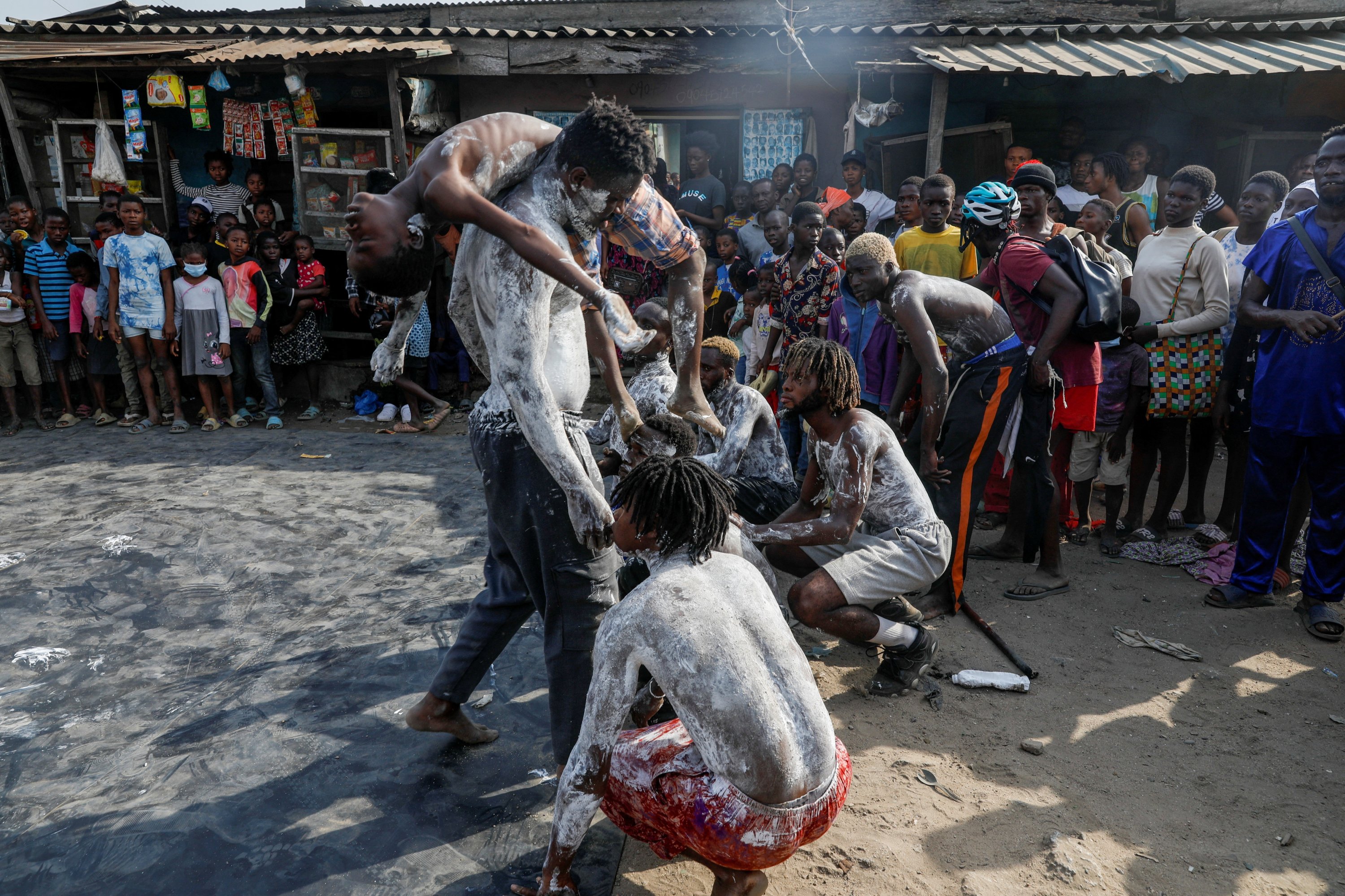 Warga menyaksikan penari tampil dalam pesta kumuh tahunan di Oworonshoki, Lagos, Nigeria, 23 Desember 2022. (Foto Reuters)
