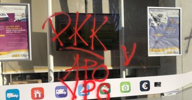 The window of a shop has the names of the PKK terrorist organization, its Syrian offshoot YPG and the acronym "Apo" suggestive of the jailed mastermind Abdullah Öcalan written in red spray paint, Paris, France, Dec. 27, 2022. (AA Photo)