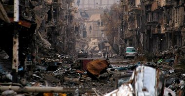 Syrians walk along a severely damaged road in the northeastern city of Deir el-Zour, Jan. 4, 2014. (AFP)
