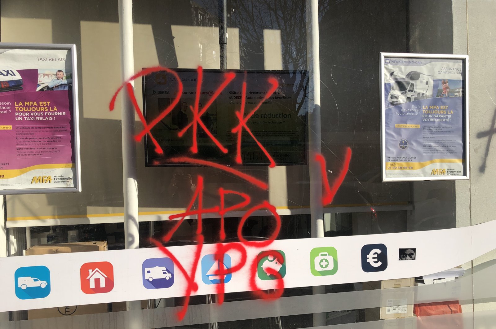 The window of a shop has the names of the PKK terrorist organization, its Syrian offshoot YPG and the acronym &quot;Apo&quot; suggestive of the jailed mastermind Abdullah Öcalan written in red spray paint, Paris, France, Dec. 27, 2022. (AA Photo)
