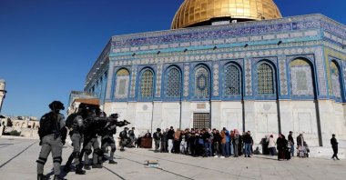 Israeli security forces stand in front of a group of Palestinians during a raid on Al-Aqsa Mosque, known to Muslims as Noble Sanctuary and to Jews as Temple Mount, in Jerusalem&#039;s Old City, April 15, 2022. (Reuters Photo)