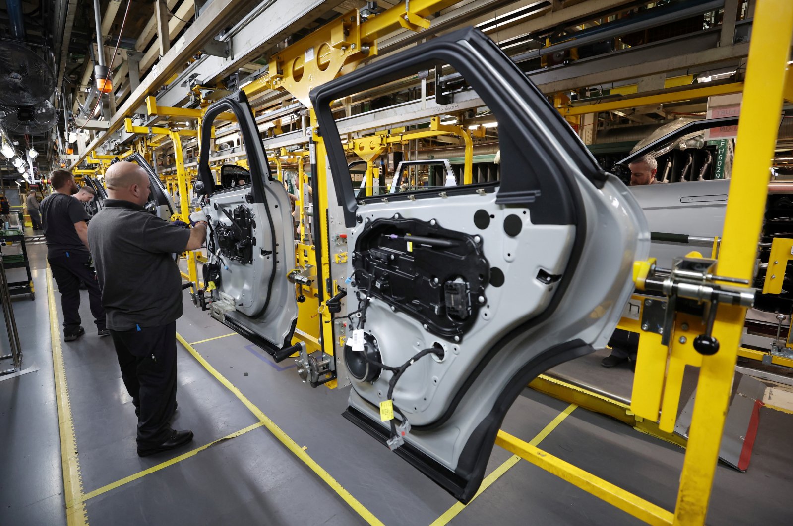 Staff members assemble door panels on the production line at Jaguar Land Rover&#039;s Halewood factory in Liverpool, Britain, Dec. 6, 2022. (Reuters Photo)