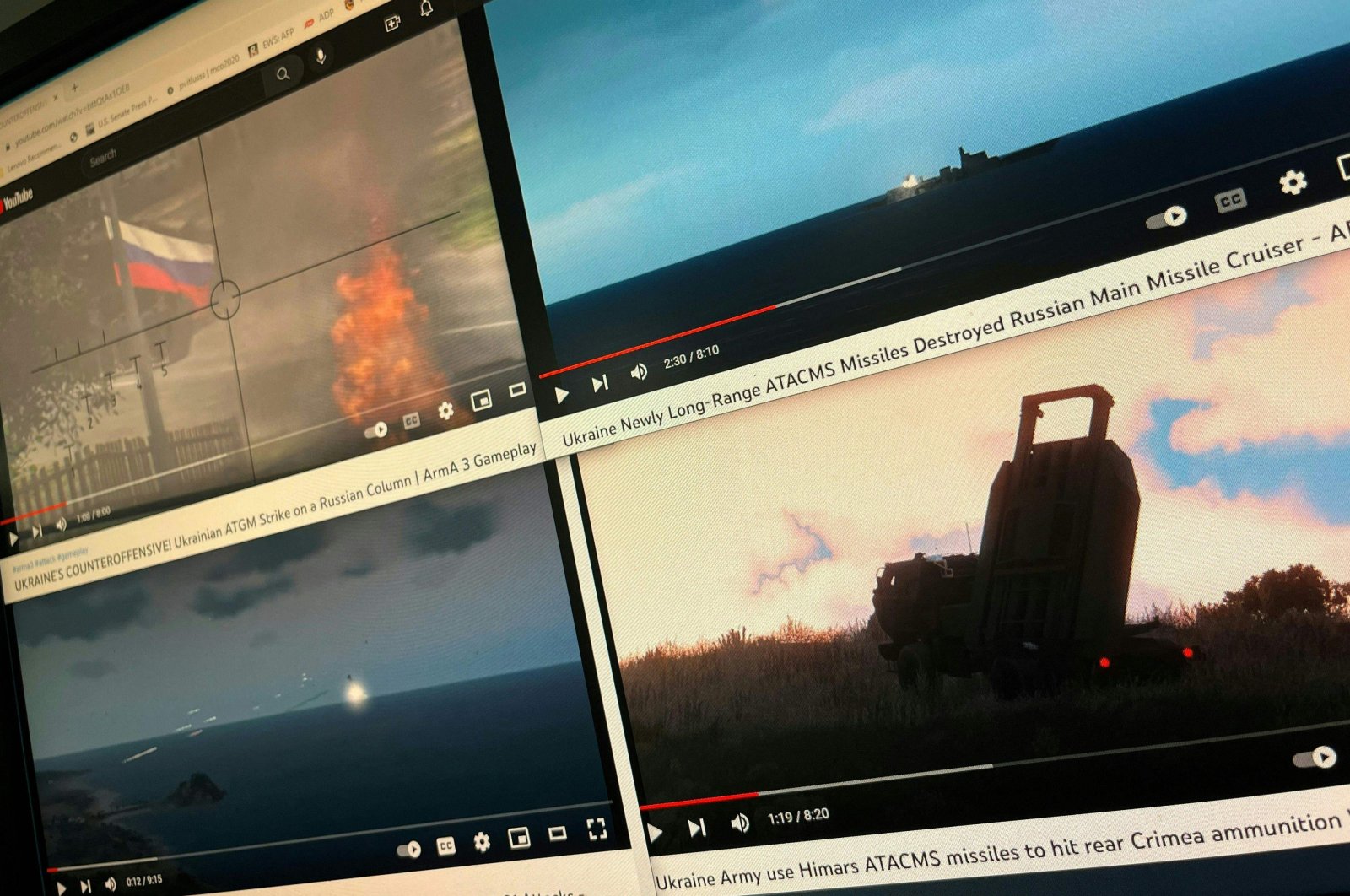 A computer screen shows four YouTube windows displaying combat clips from Arma 3&#039;s war-themed video games, Washington, U.S., Dec. 28, 2022. (AFP Photo)