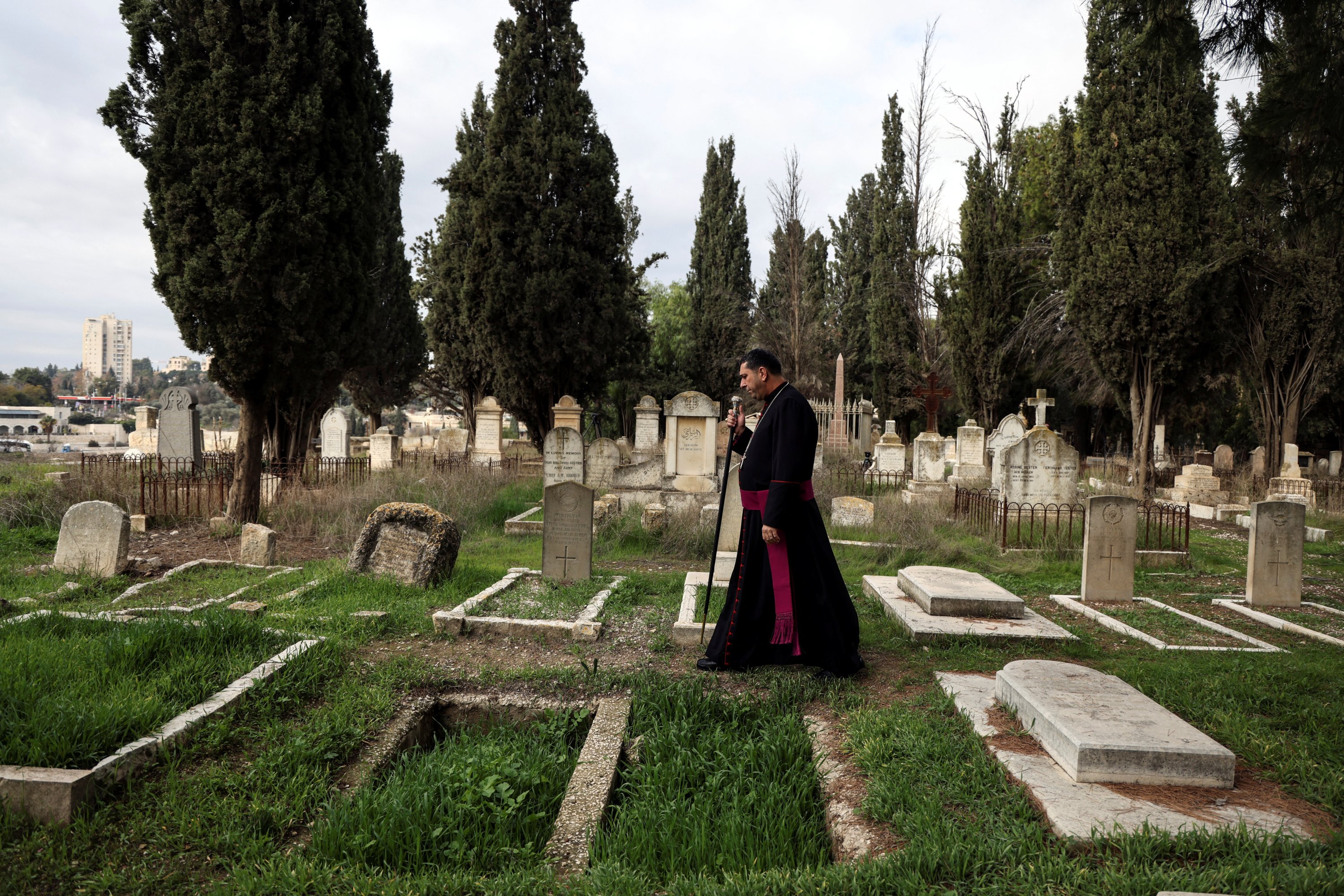 Archbishop Hosam Naoum walks through Protestant Mount Zion Cemetery where tombstones have been vandalized in Jerusalem, Jan. 4, 2023. (Reuters Photo)