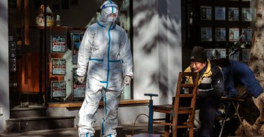 A woman in protective gear stands on the street, in Shanghai, China, Jan. 4, 2023. (EPA Photo)