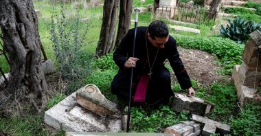Archbishop Hosam Naoum inspects a vandalized tombstone at the Protestant Mount Zion Cemetery in Jerusalem Jan. 4, 2023. (Reuters File Photo)