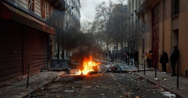 Smoke billows from a fire in a ravaged street, as PKK terrorist group supporters face off with riot police in violent clashes, in Paris, France, Dec. 24, 2022. (AA Photo)