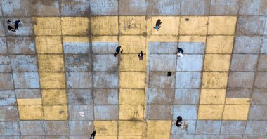 Activists clean an image of the Crimean Tatars' national flag on the ground in Kyiv, Ukraine, June 27, 2020. (AP Photo)